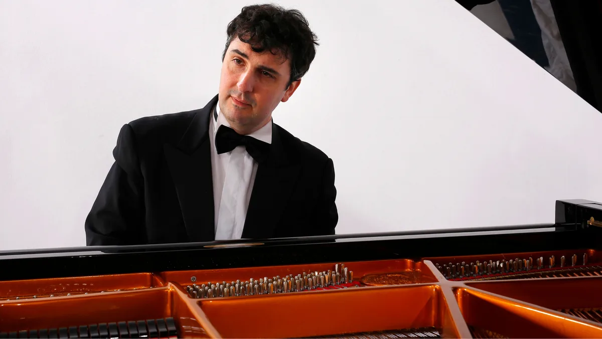 Antonio Davì spielt am 9. Januar 2026 bei Piano Sigrist in Hinwil. Der Pianist Antonio Davì sitzt am offenen Flügel. Er trägt einen schwarzen Smoking mit Fliege.